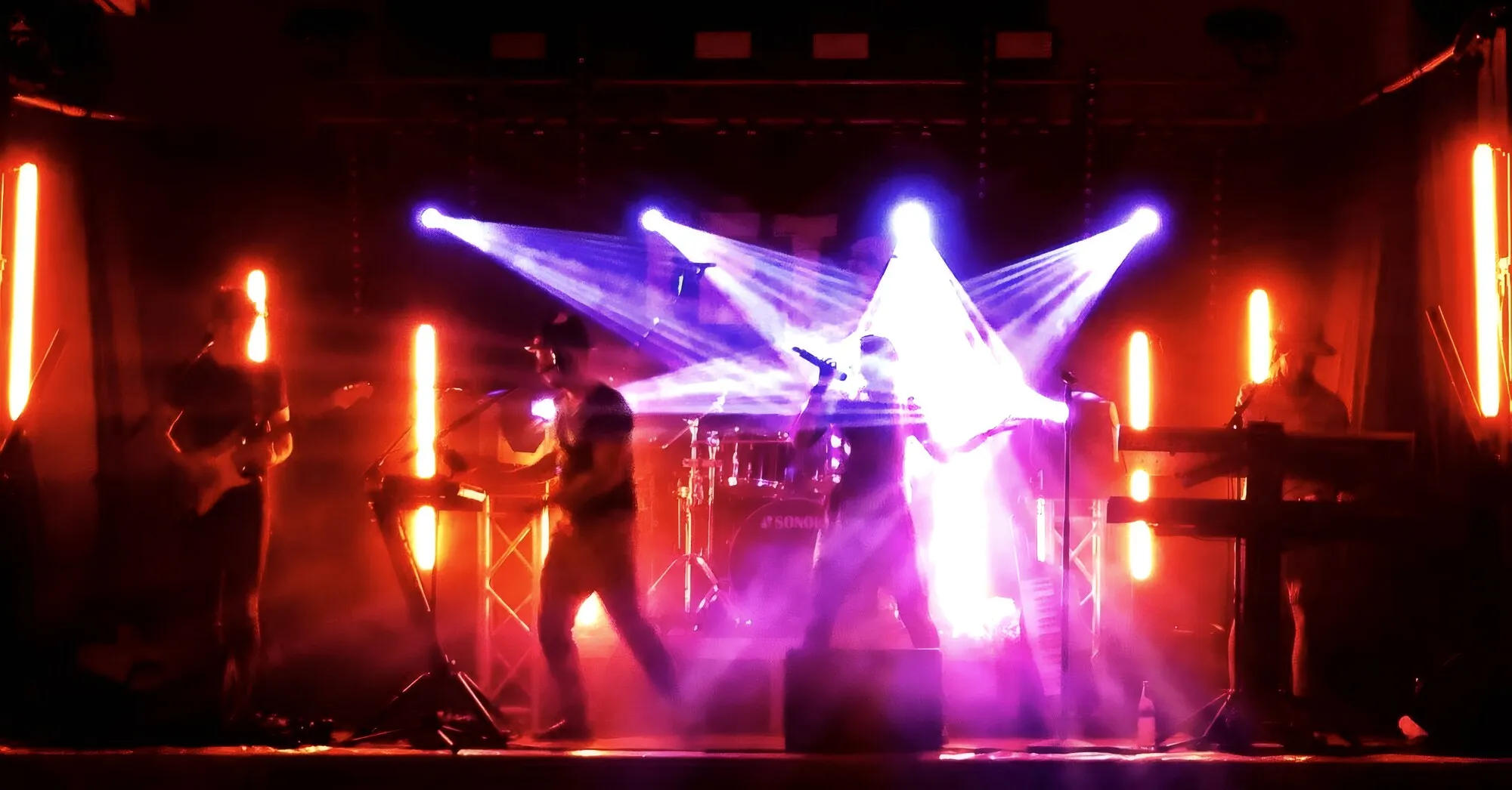 Bühne mit Moving Heads in rotem Licht bei einem Konzert