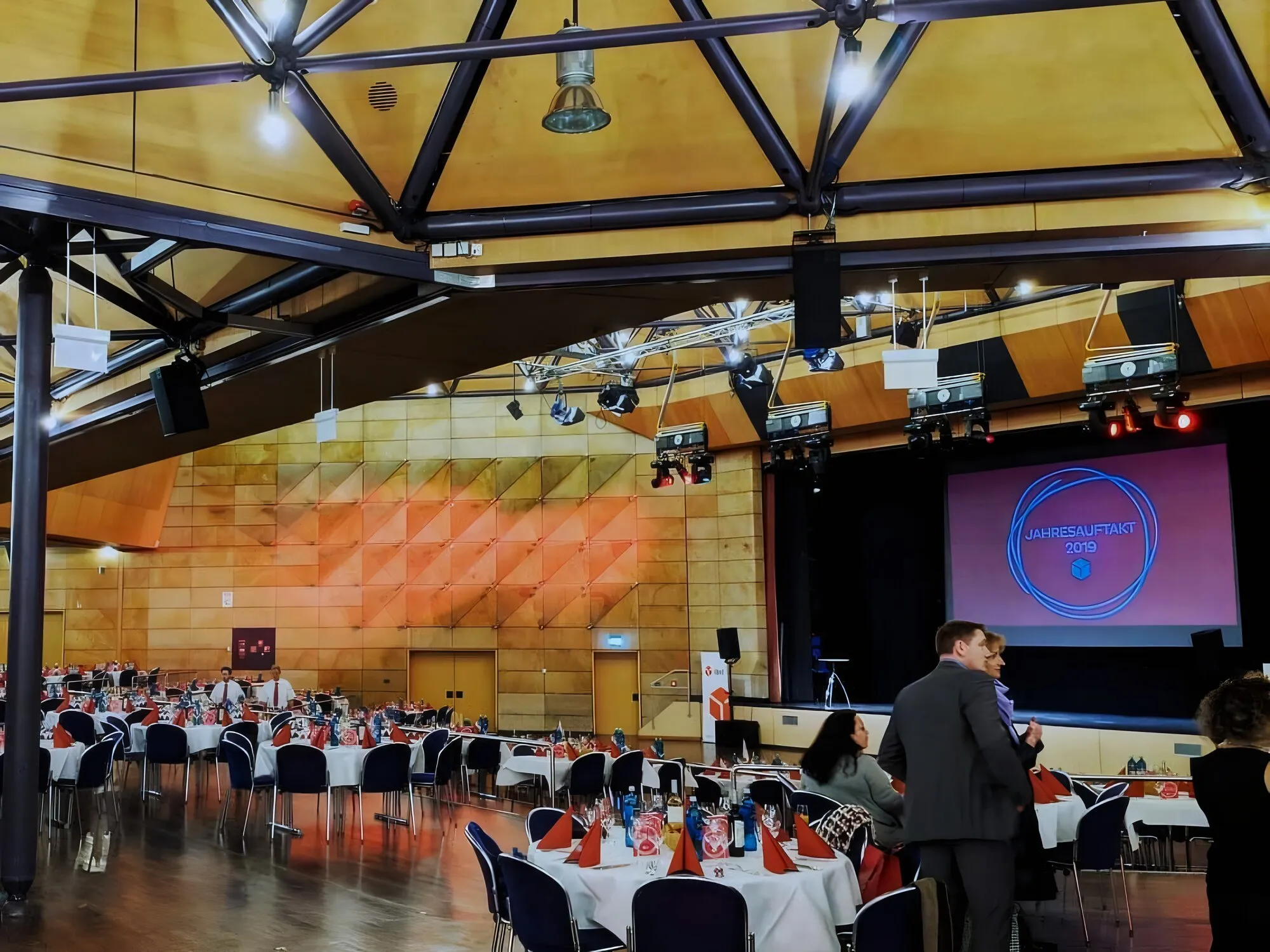 Festlich gedeckter Saal mit Bühne und warmer Ausleuchtung bei einem Galaabend