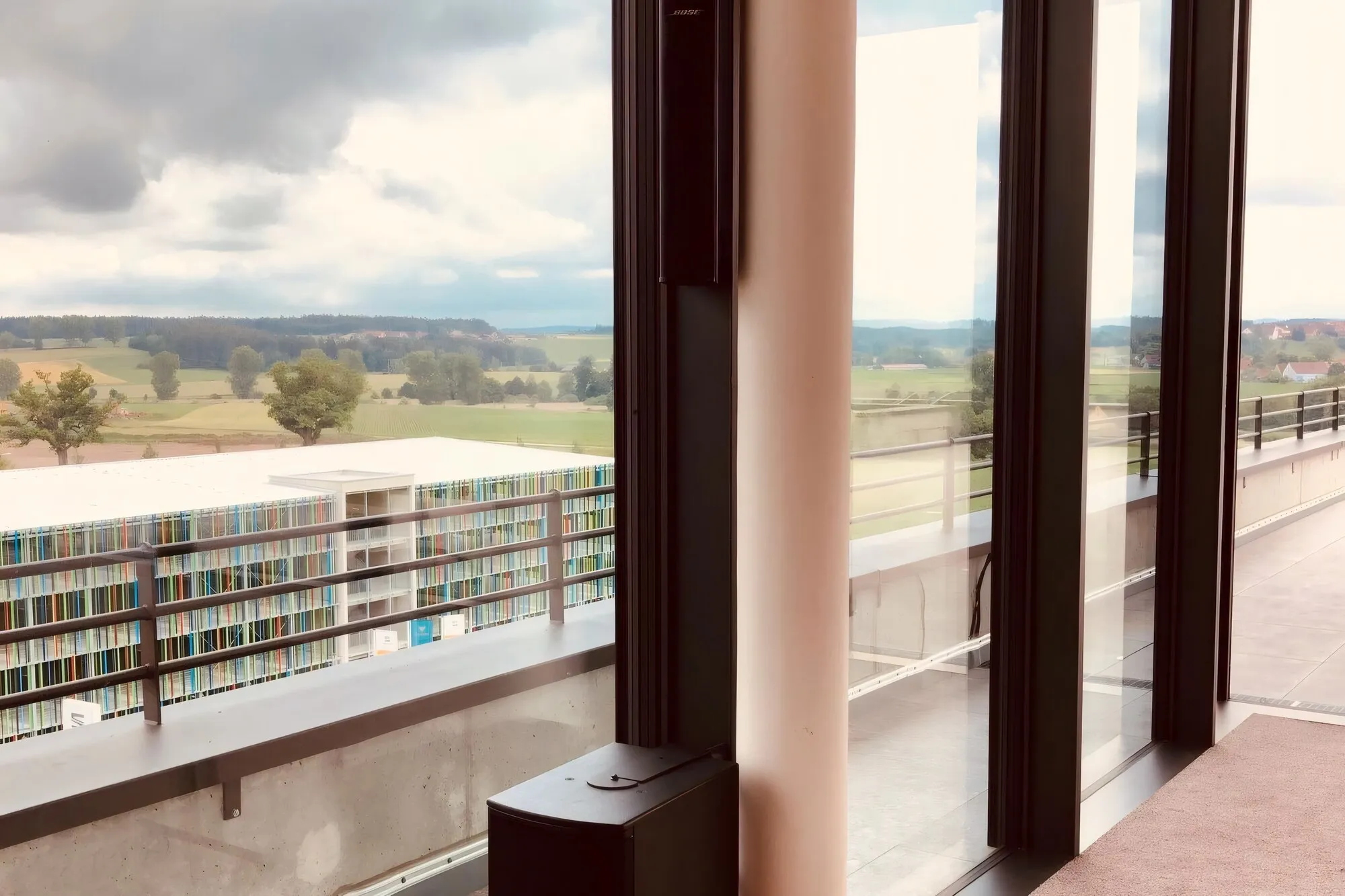 Tagungsraum mit bodentiefer Fensterfront, Panoramablick und schlankem Säulenlautsprecher