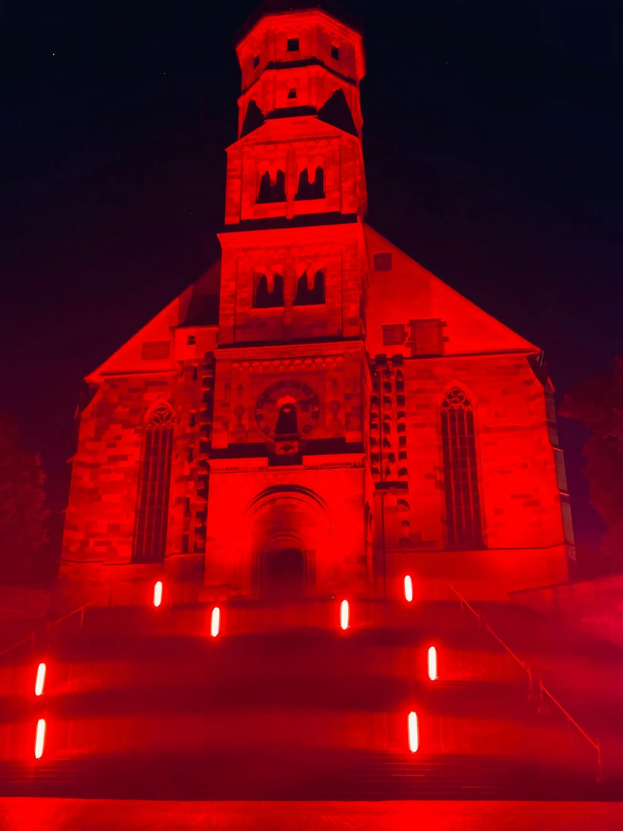 Die Kirche St. Michael in Schwäbisch Hall nachts vollflächig in Rot angestrahlt